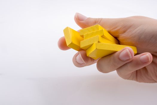 Hand holding yellow color domino pieces in hand