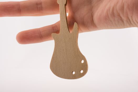 Mini wooden guitar model in hand on a white background