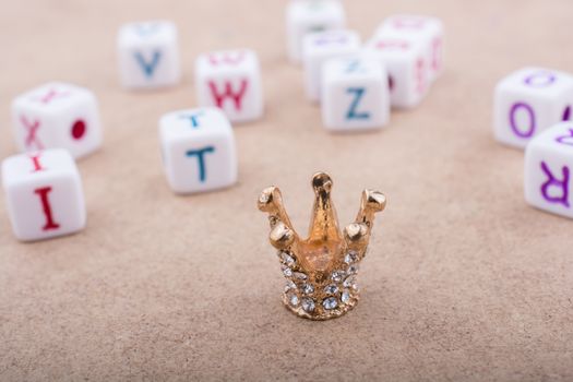 Golden color crown model in front of the letter cubes