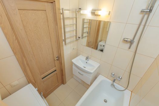 Small beige tile bathroom with bath tube and sink