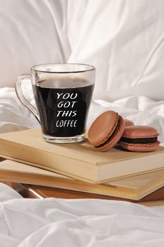 Morning cup of coffee with chocolate cakes Macaroons, on a pile of books in bed.
You got this coffee.
