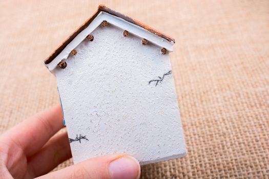 Little model house and  a hand  on a light  brown color background