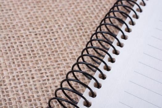 brown color spiral notebook placed on a canvas background
