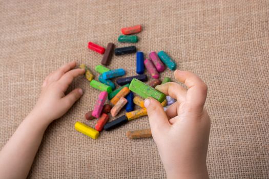 Used  color crayons and a toddlers hand holding one