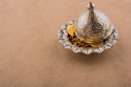 Fake gold coins in an old decorative metal  plate