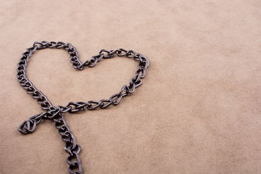 Chain form a heart shape on a brown background