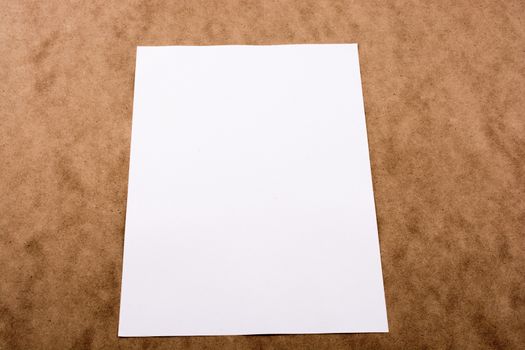 A sheet of A4 white blank paper,  paint brush and a watercolor paints on a board