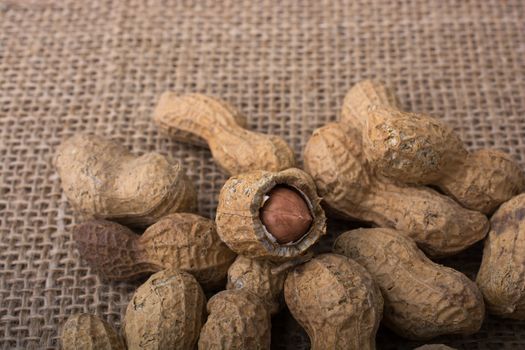 Peanuts with shell on linen canvas background