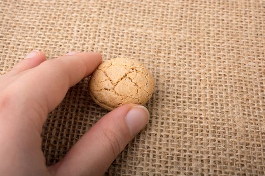 Turkish almond cookie in hand on a linen canvas
