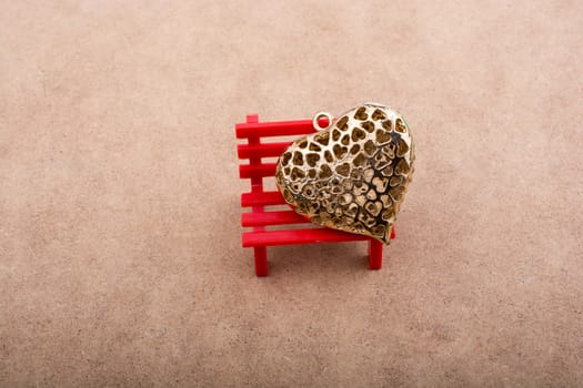 Heart shaped object placed on red bench