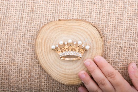 Hand holding a little model crown in hand