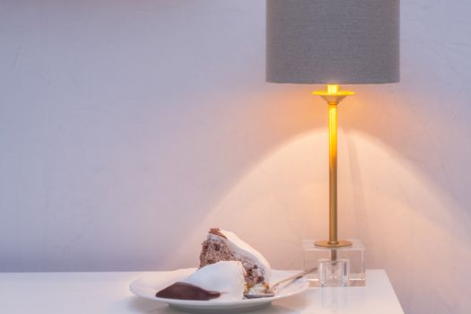 Two slices of sweet pie on table with lamp in evening