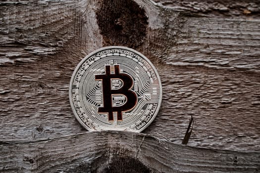 Digital currency physical silver bitcoin coin on the wooden background.