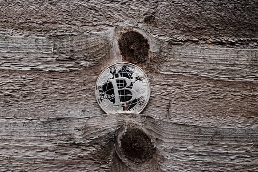 Digital currency physical silver bitcoin coin on the wooden background.