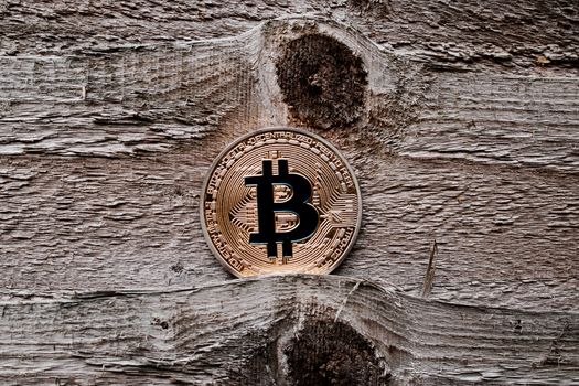 Digital currency physical gold bitcoin coin on the wooden background.