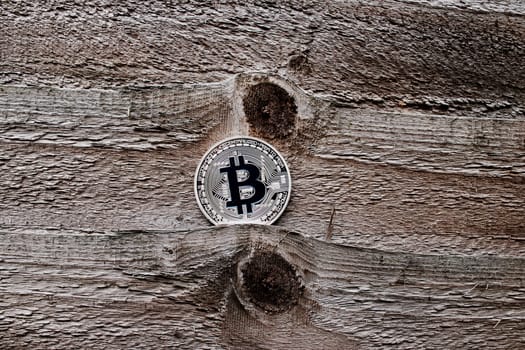 Digital currency physical silver bitcoin coin on the wooden background.