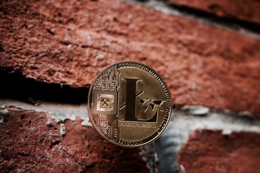 Digital currency physical gold Litecoin coin on the brick wall.
