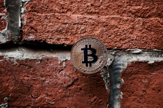 Digital currency physical gold bitcoin coin on the brick wall.