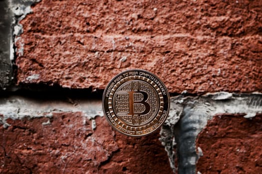 Digital currency physical gold bitcoin coin on the brick wall.
