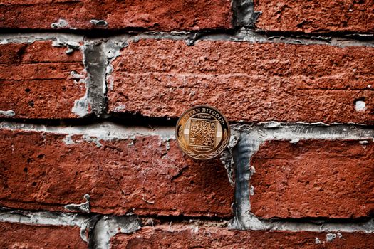Digital currency physical gold titan bitcoin coin on the brick wall.