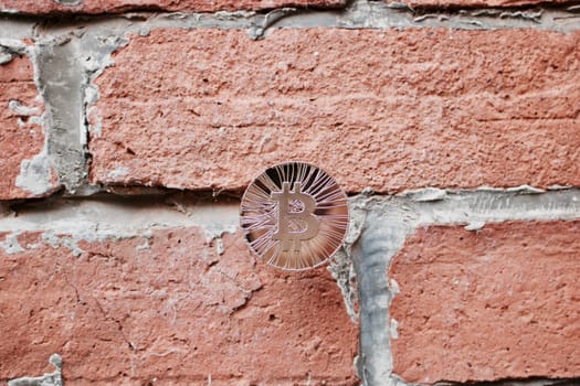 Digital currency physical gold bitcoin coin on brick wall. Business concept.