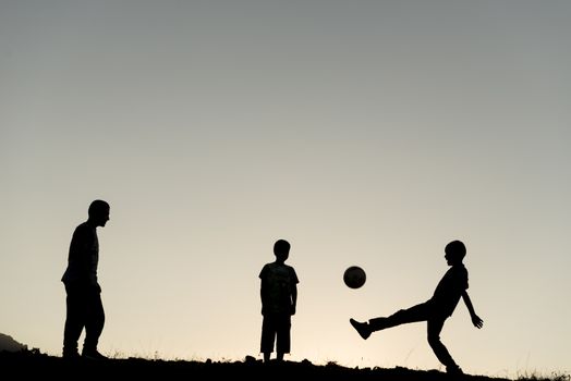 Children playing soccer in the nature