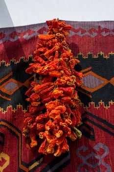 Bundles of red peppers dry in the sun
