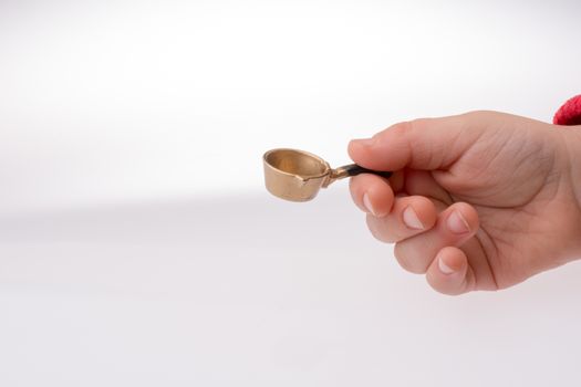 Hand holding a little model pan as a kitchen utensil
