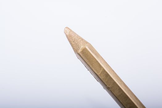 Hand holding a gold color pencil on a white background