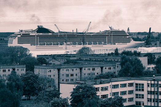 Large cruise liner sailing past the cargo port. Monochrome