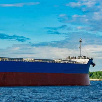 Merchandise import. Large blue cargo ship moving to Riga port