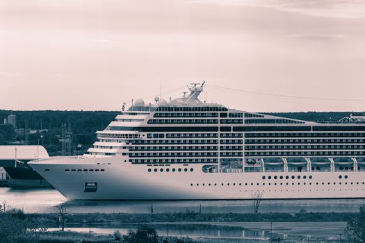 Large cruise liner sailing past the cargo port. Monochrome
