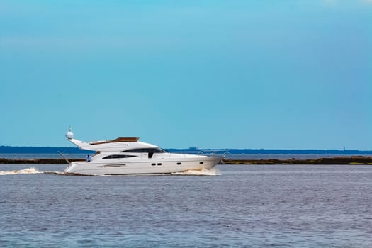 White speed boat moving fast to the Baltic sea. Water sport