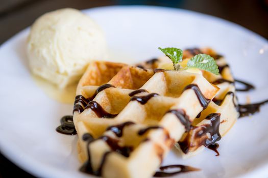 waffles with ice cream with chocolate and mint leaf