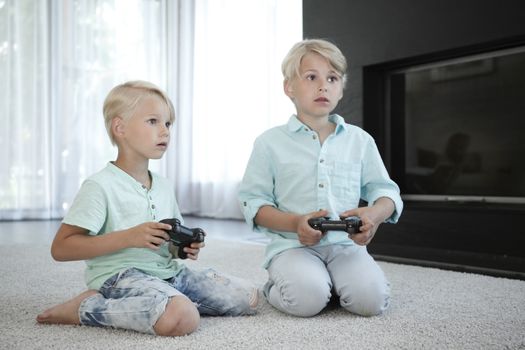 Two brothers playing video games at home