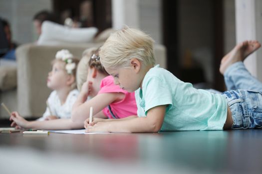 Group of cute children drawing with colorful pencils on floor