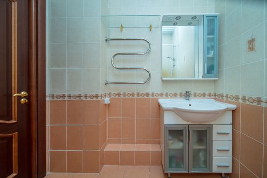 Small beige tile bathroom with bath tube and sink