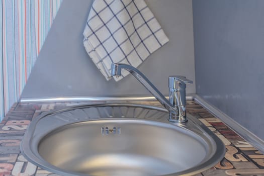 Close up of modern faucet and ceramic sink in kitchen