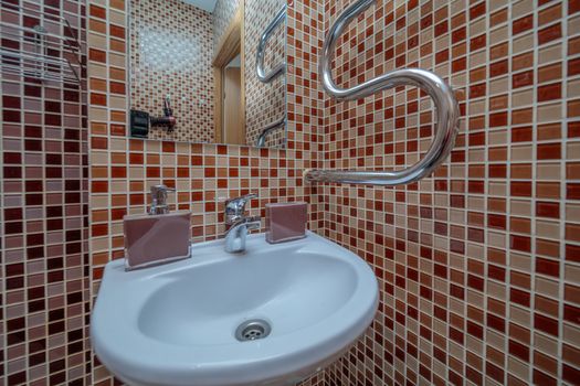 Close up of modern faucet and ceramic sink in bathroom