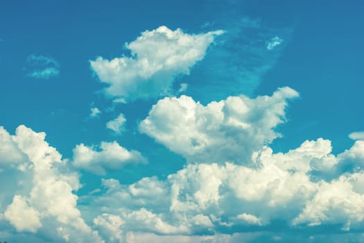 Deep blue bright sky with white fluffy clouds