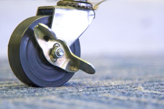 Small black rubber wheels on the carpet.