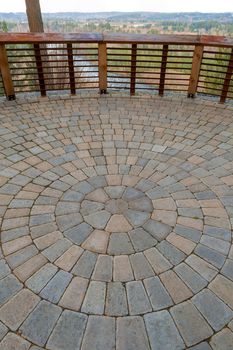 Garden Backyard circular brick stone pavers hardscape patio with wood railings stone wall view deck