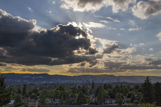 Afternoon sun rays through clouds over city of Portland Oregon downtown skyline