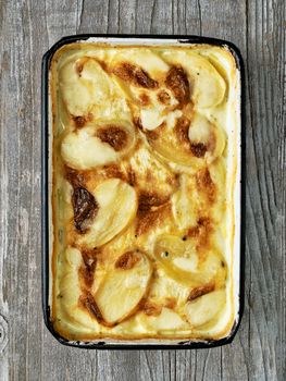 close up of rustic golden scalloped potato gratin dauphinois