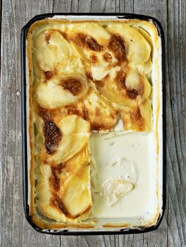 close up of rustic golden scalloped potato gratin dauphinois