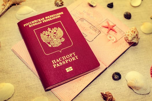Passport and seashells on the background of sand, travel concept.