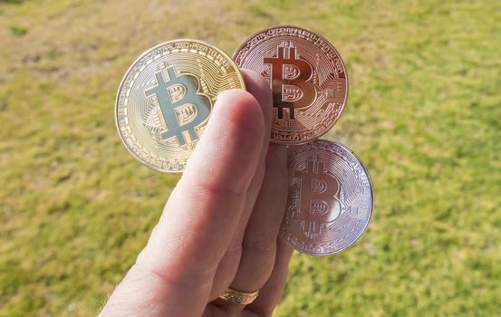 Cryptocurrency coins in a hand; Bitcoin