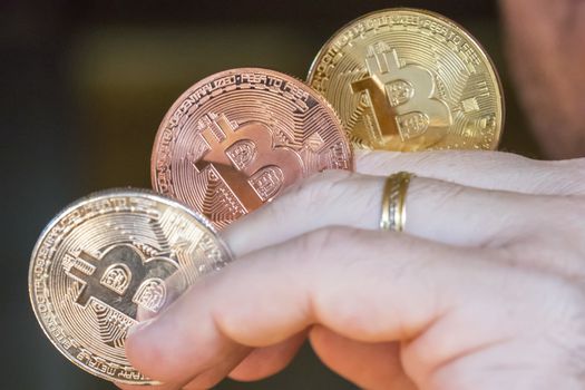 Cryptocurrency coins in a hand; Bitcoin