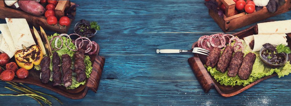 Grilled lmeat dish, with vegetable on a blue wooden background