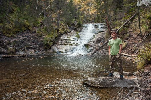 Man standing in front of waterfall in Altai mountains